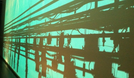 Shadows of stage lighting on a green background.