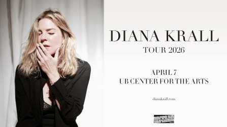 diana krall posing with her hand over her mouth and eyes closed in front of a blank curtain.