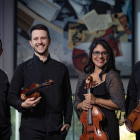 members of dali quartet posing with string instruments. 