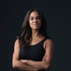 misty copeland in front of dark background with arms crossed. 