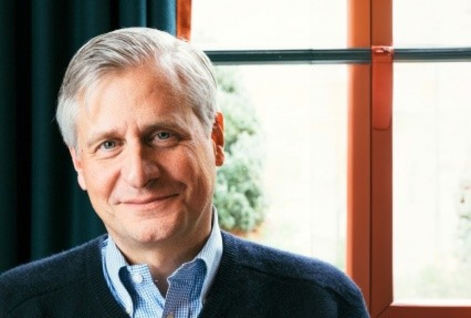 portrait of Jon Meacham sitting in front of a window. 