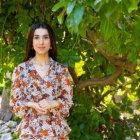 nadia murad standing in front of a tree. 